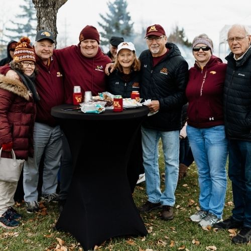 Chancellor Mary Holz-Clause with her husband, faculty and staff at a tailgate
