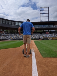 Photo of Brayton working as a grounds crew member for a minor league baseball team
