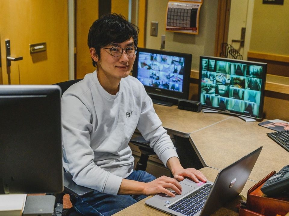 International student working at the front desk of Centennial Hall