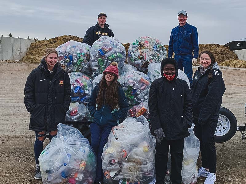 Students with a big pile of recyclable aluminum cans 