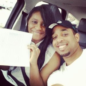 Brandt Moore and his wife holding a piece of paper in a car