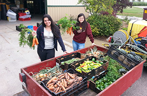 Students holding produce from the campus garden