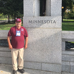 Gary Weiss standing in front of the Minnesota statue