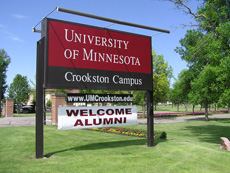 Campus Entrance sign with a temporary "welcome alumni" hanging sign