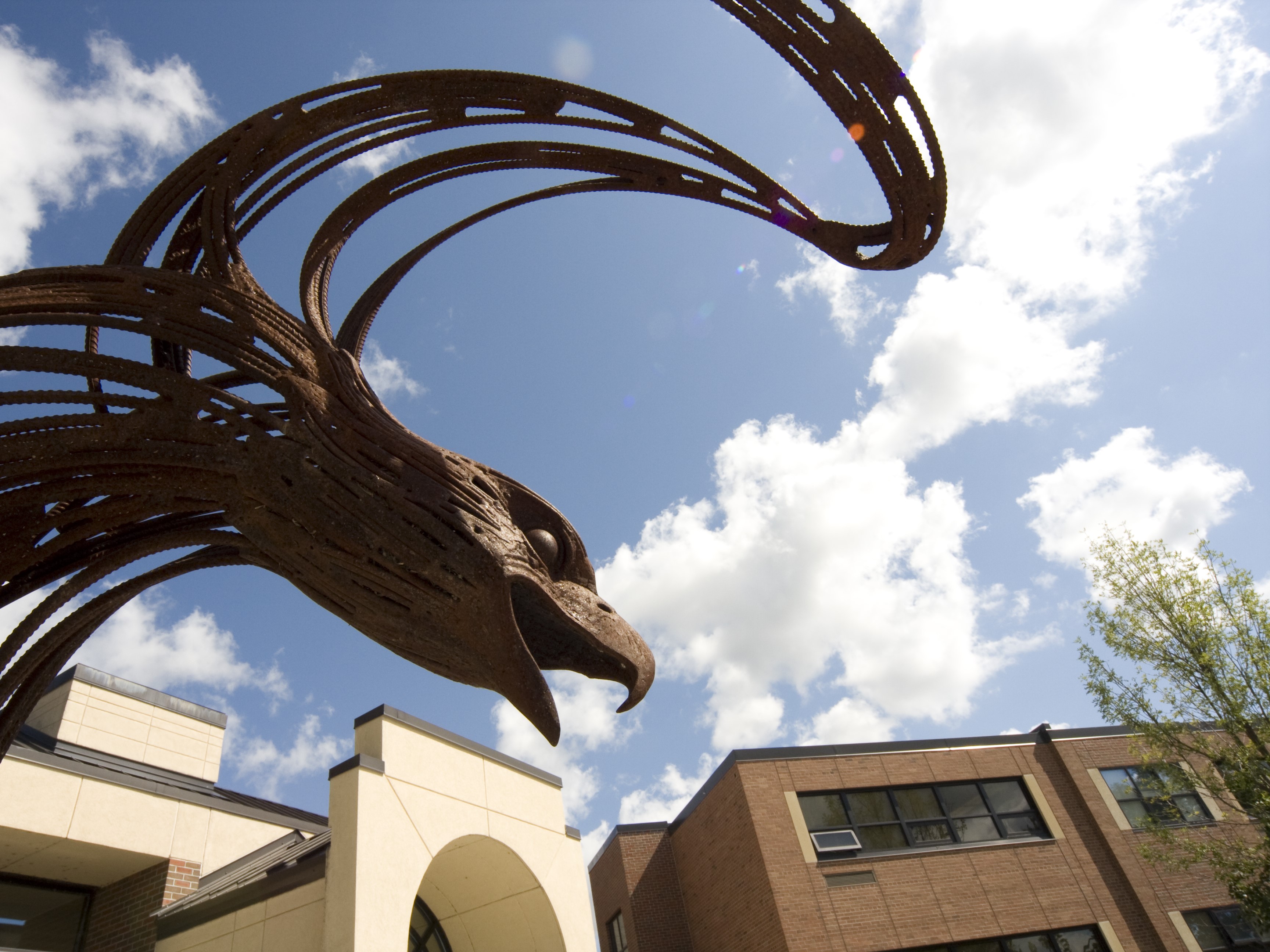 A stylized eagle sculpture against a bright blue sky