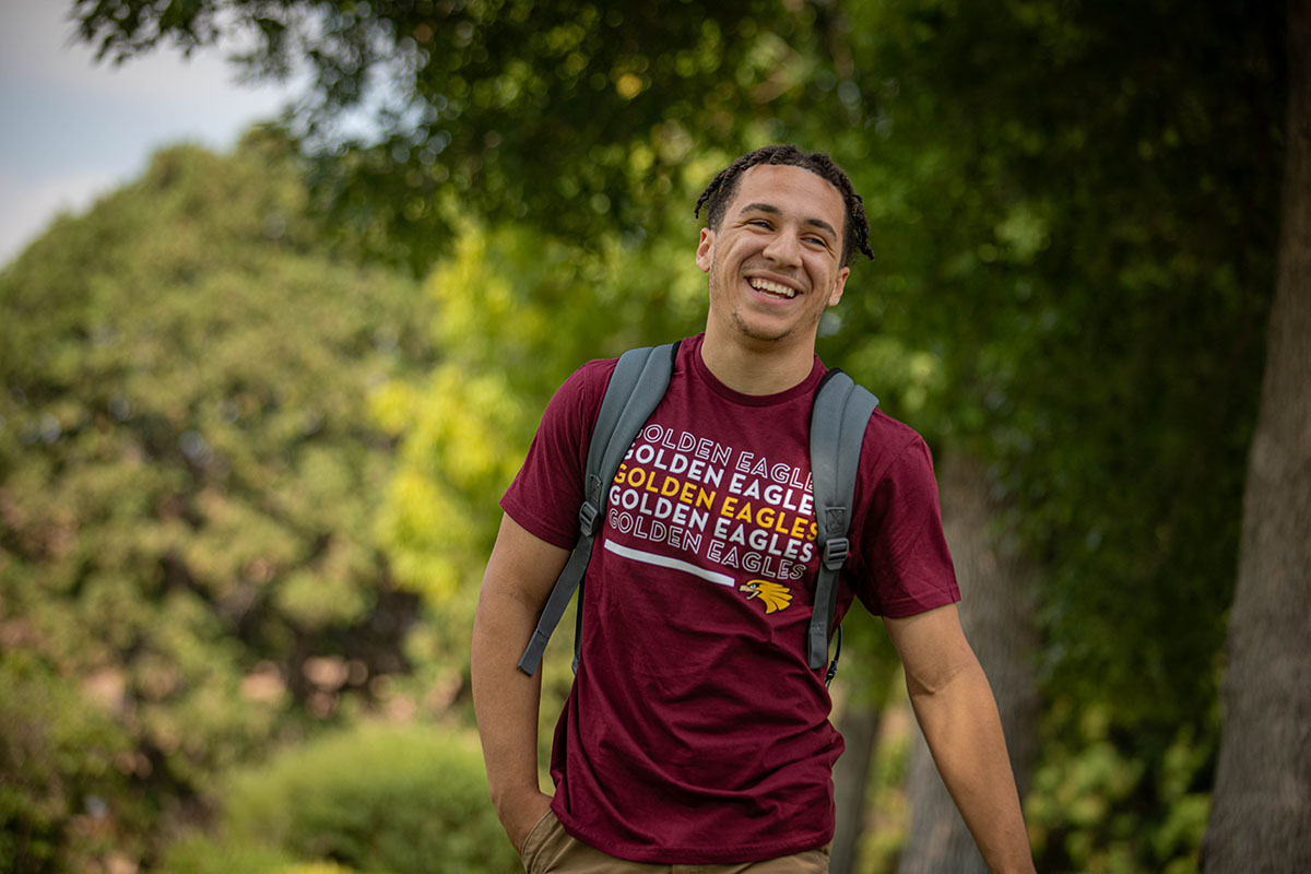 UMN student smiling while walking on campus. 