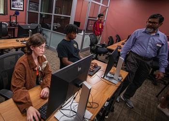Students working with faculty in the computer lab
