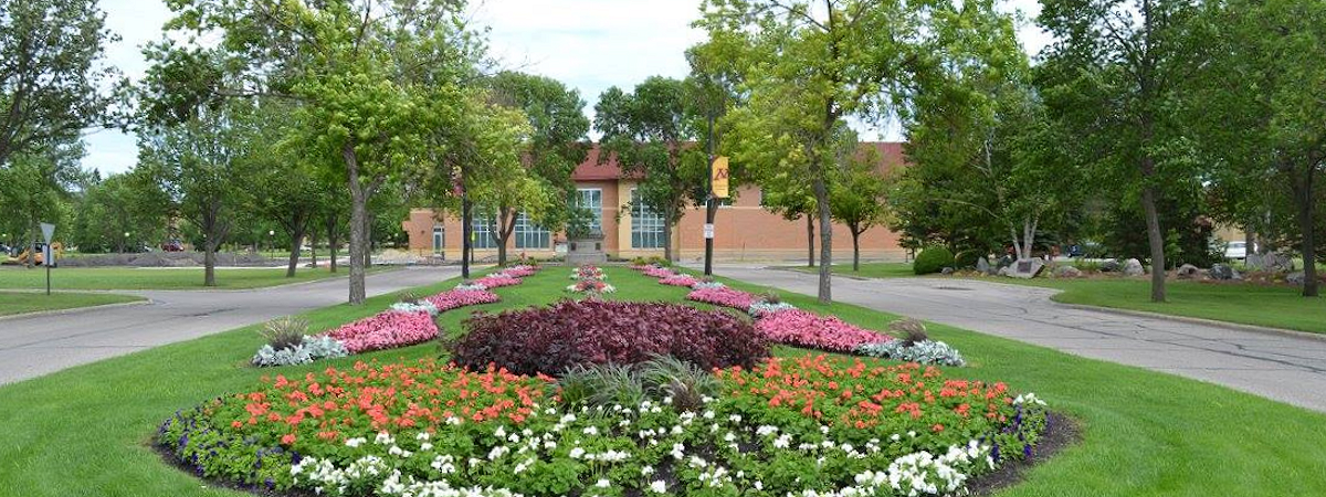 Main campus entrance, with many brightly colored flower beds.