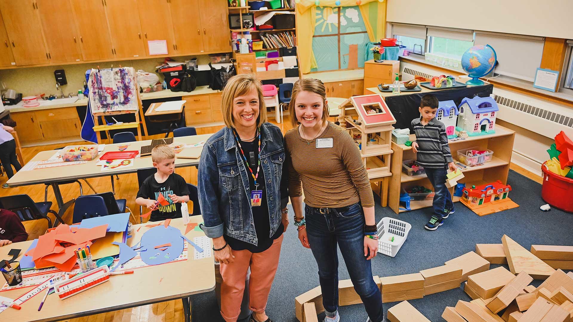Karen and Karlie Brekken standing in a classroom.