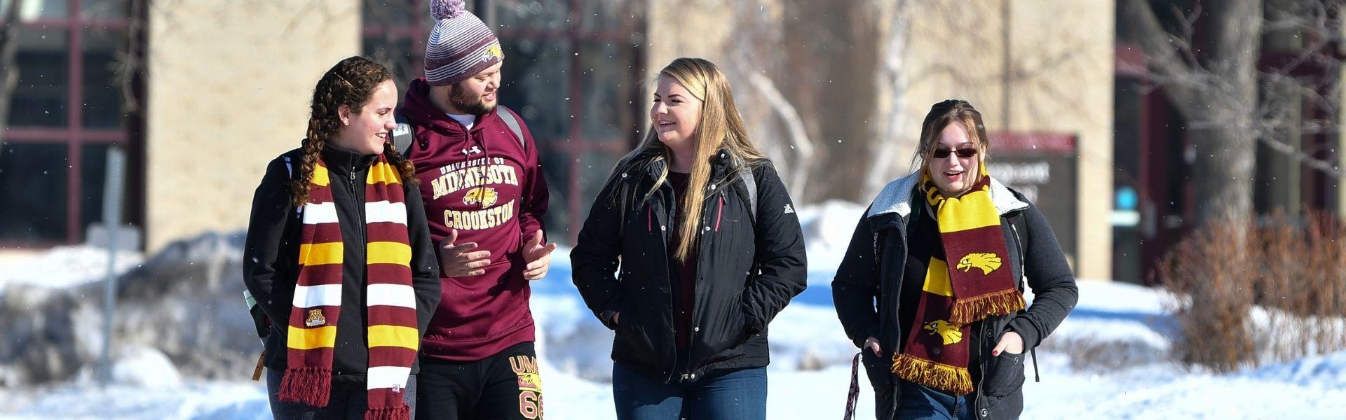 Four students walking outside in the winter with Golden Eagle clothing.