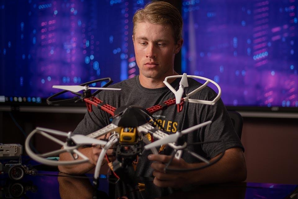 Student working with a drone in a computer lab