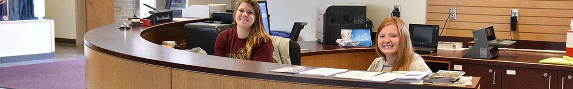 Two students sitting at the Information Desk in Sargeant Student Center