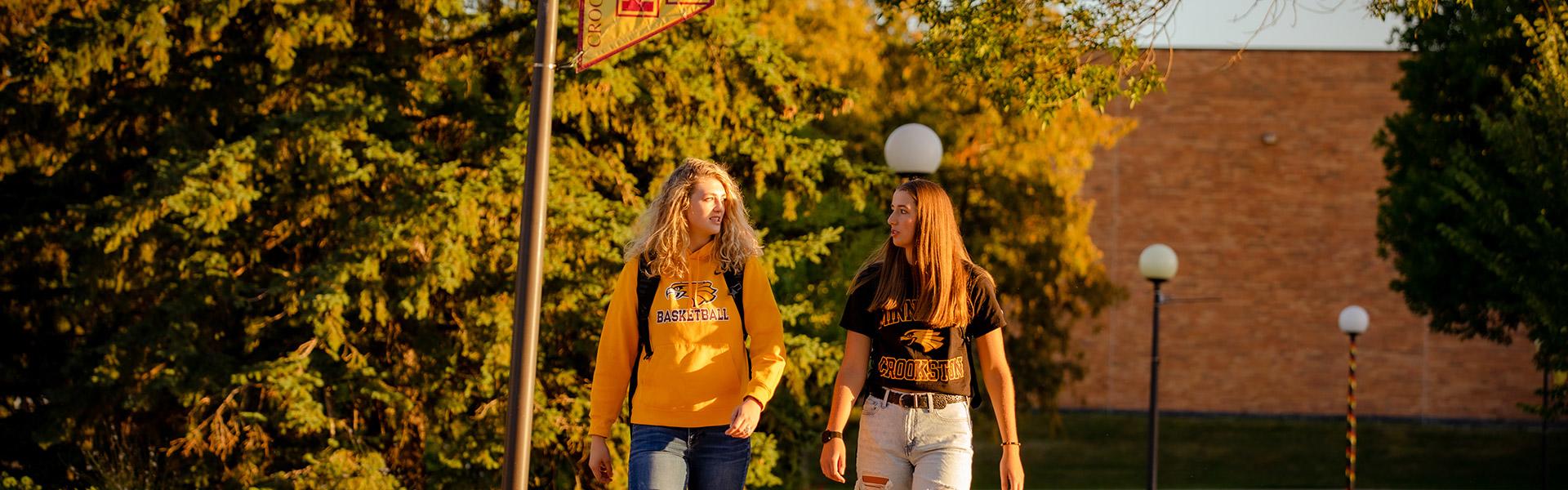 Two students walking on the mall in the morning sun