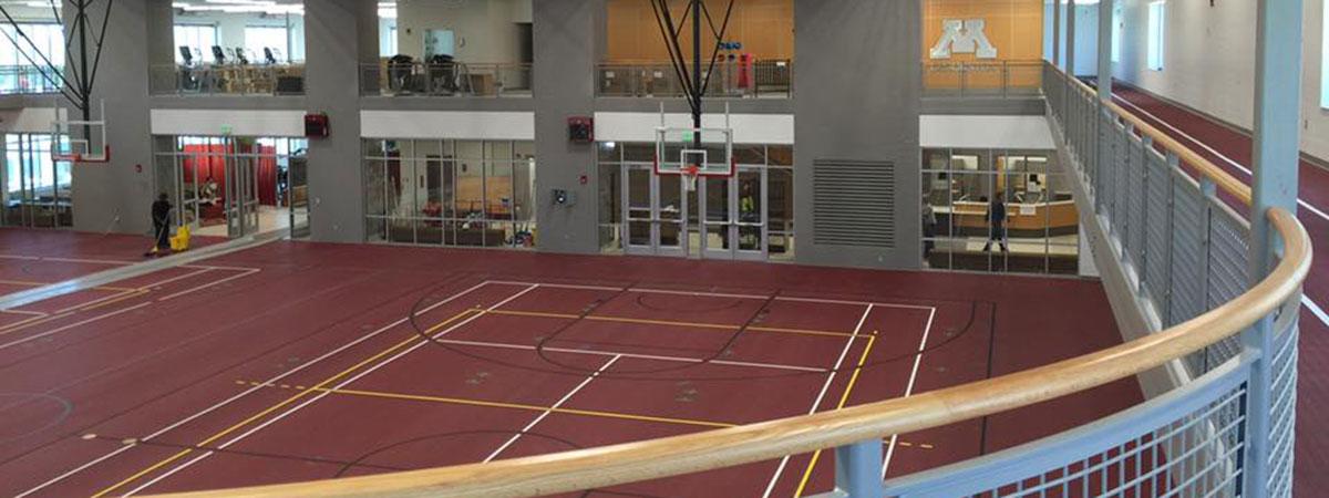 Wellness Center two court gymnasium and running walking track looking into the weightlifting and cardio area