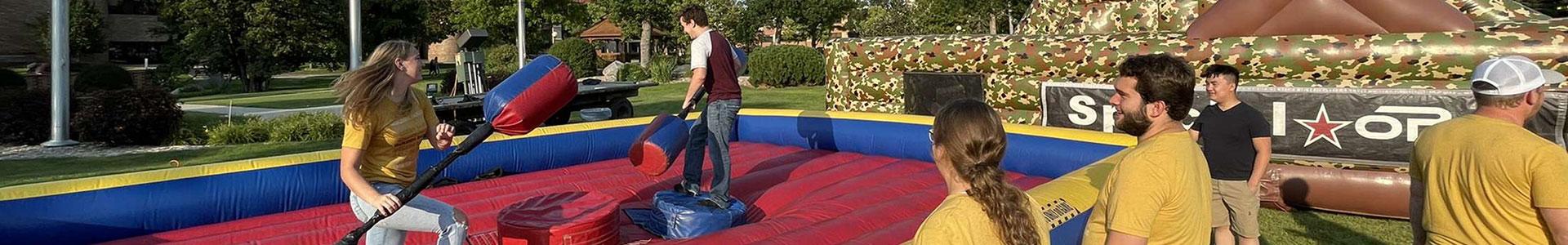 Students battling on giant blow up toys on the Campus Mall