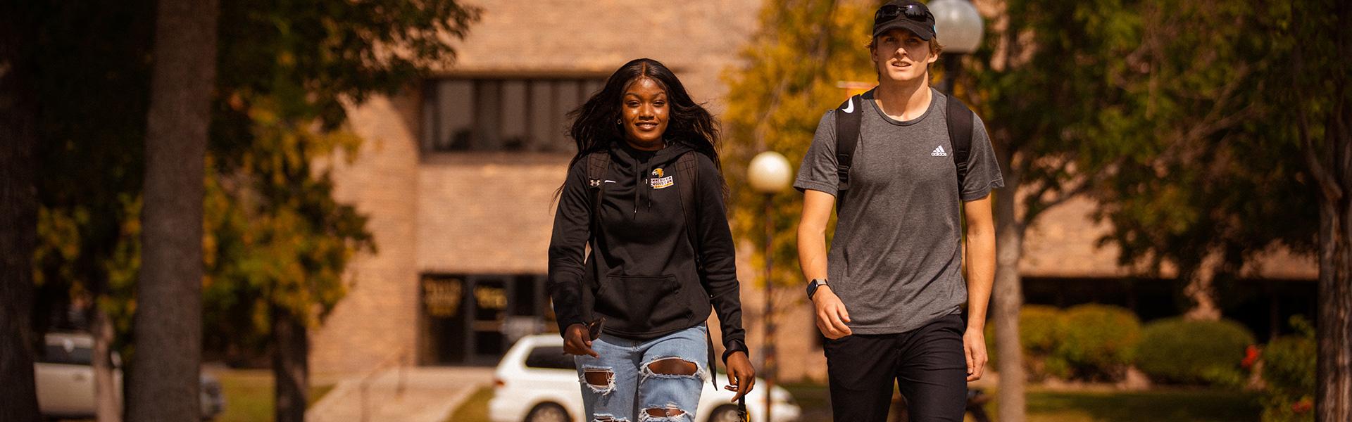 Female and Male student walking outside Sahlstrom Conference Center