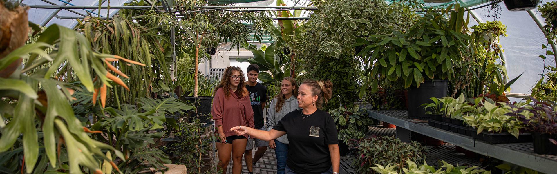 U of M Crookston instructor Theresa Helgeson and and students walking through the greenhouse