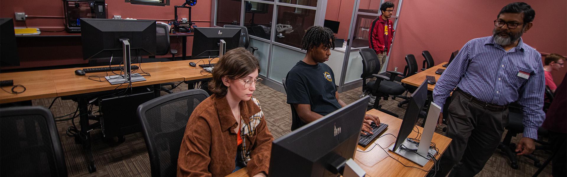 Information Technology students and professor working in a classroom in Dowell Hall