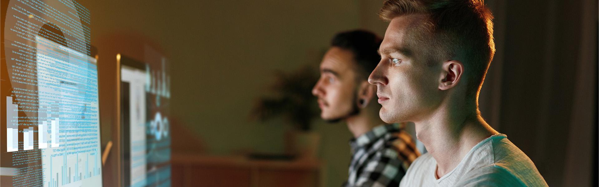 Two males looking intently at their computer screens