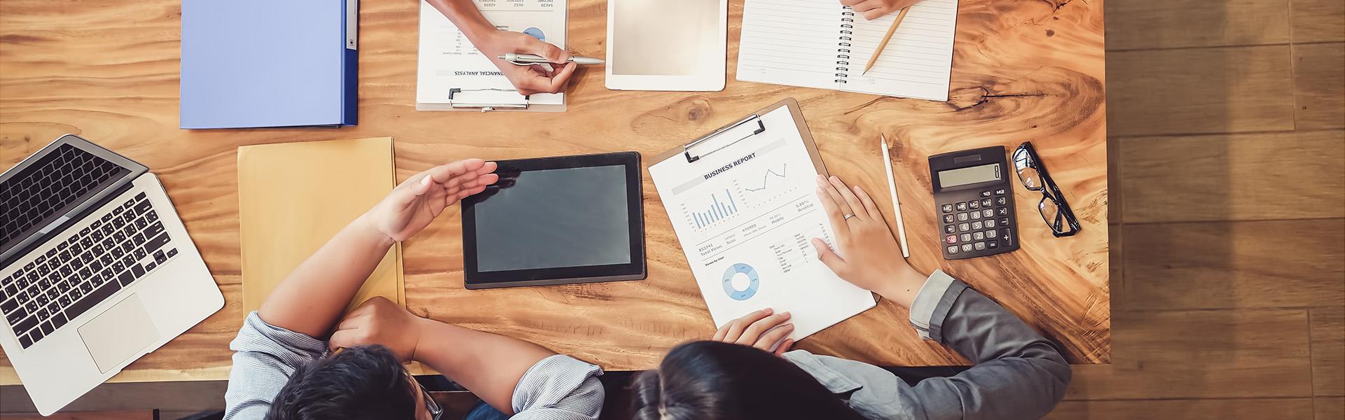 Group of four marketing professionals looking over data at a table