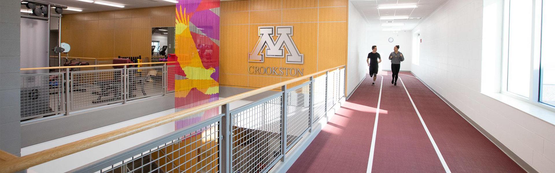 Two students running on the second floor track in the UMC Wellness Center