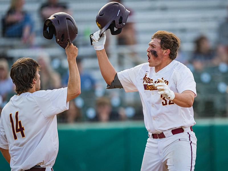 Two Golden Eagle baseball players celebrating after a winning run