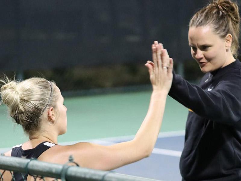 Singles player getting a high five from the assistant coach