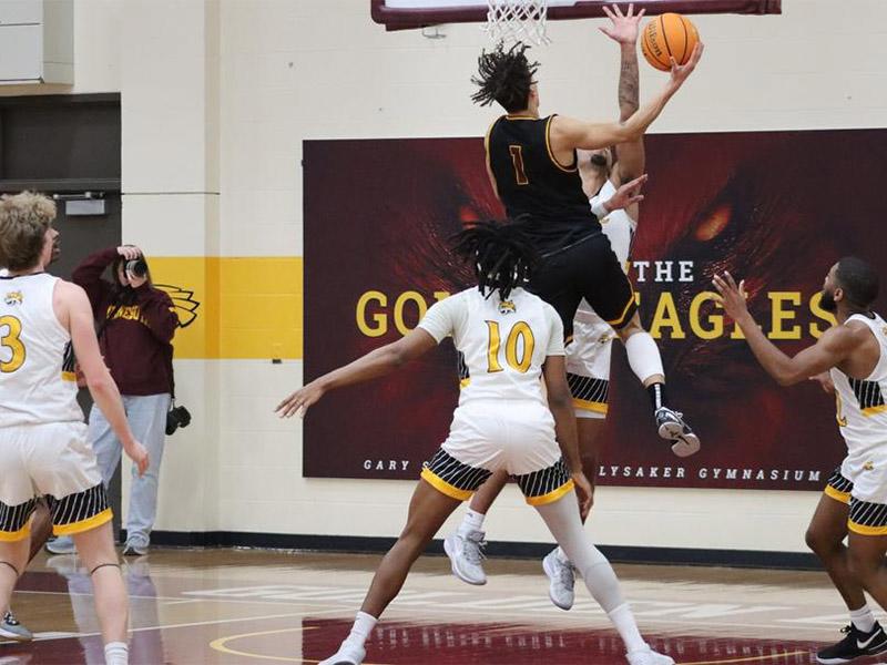 Golden Eagle men's basketball player going up for a contested lay-up