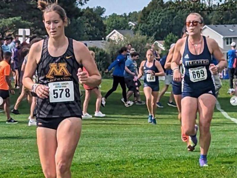 Golden Eagle women's cross country runner out front of another school