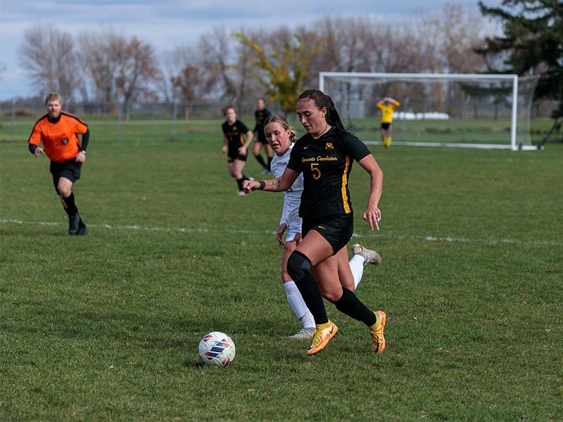 Golden Eagle soccer player kicking the ball from an opponent