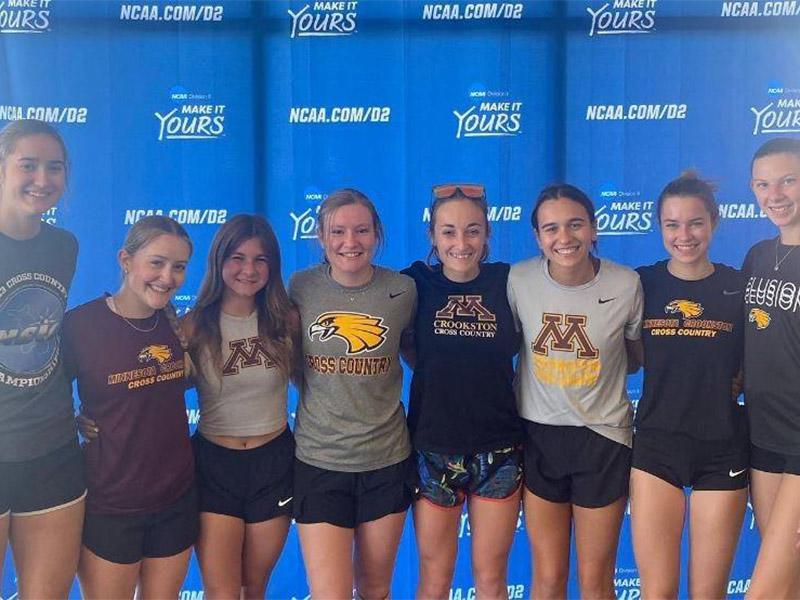 Golden Eagle women's cross country team in front of NCAA Division 2 background