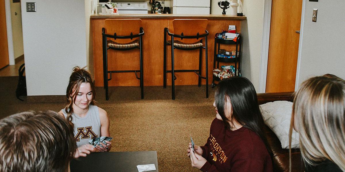 Students gathered together playing cards in their dorm room located in Centennial Hall.