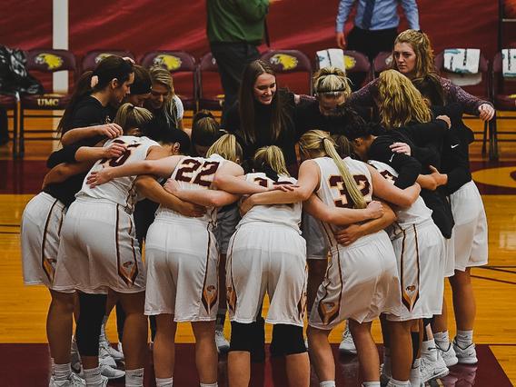 Women's Basketball team in a huddle during a game