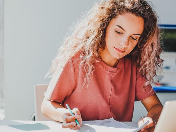 Female student writing at a desk