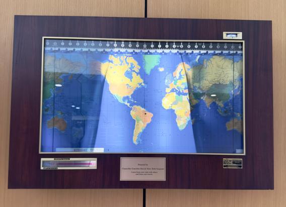 Framed and lighted global clock hanging on the south wall of the International Lounge in Sargeant Student Center