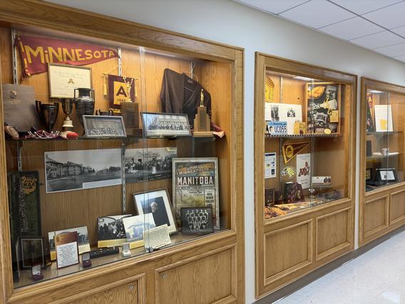 Glass display cases in the hallway of Kiehle Building displaying the three eras of the University.