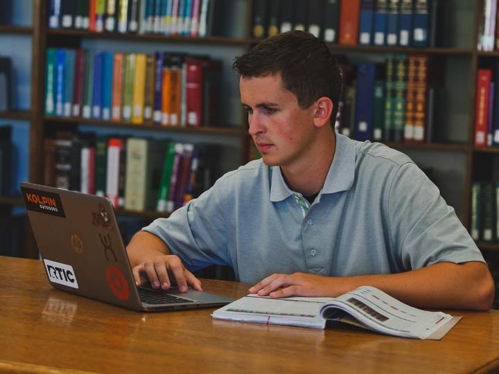 Student in the UMC Library on a laptop