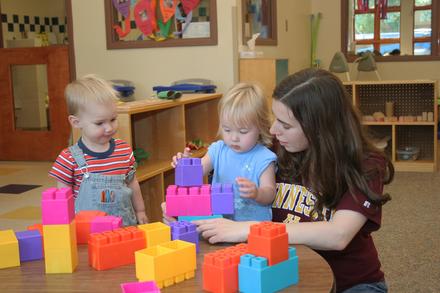 ECDC teacher with children in the classroom playing with building blocks