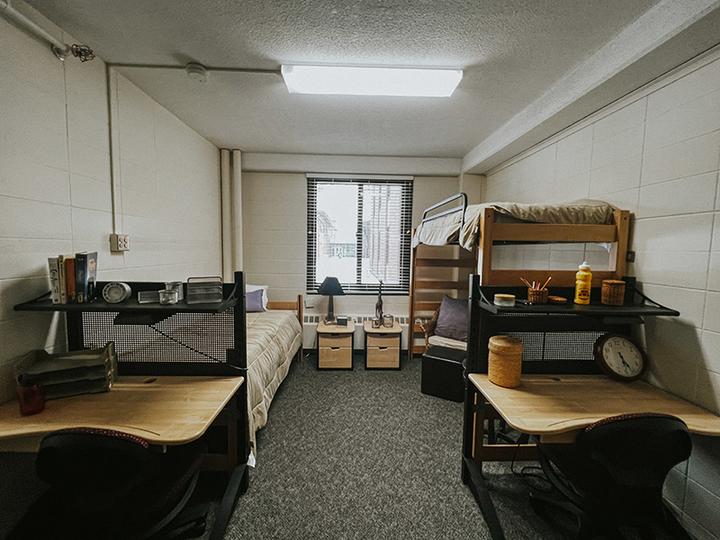 Skyberg Room, looking from the door at two beds and two desks and a window. One bed is at a normal height and one is lofted.
