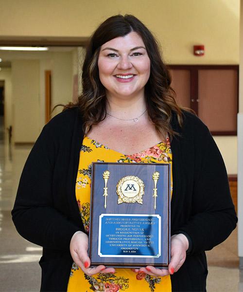 Brooke Novak holding her Distinguished Professional and Administrative award plaque in Kiehle Building Rotunda