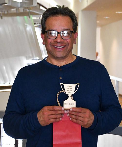 Ken Mendez holding his wooden "Fan of the Year" award outside of the Northern Lights Lounge