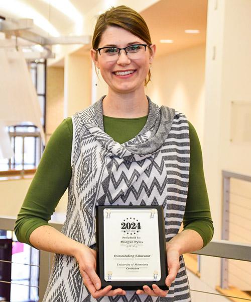 Morgan Pyles holding her 2024 Outstanding Educator Plaque in Sargeant Student Center