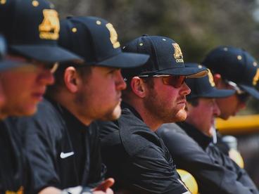 Baseball team leaning over the fence