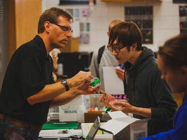 Faculty member working with an international student in a lab