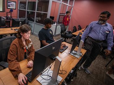 Students working with faculty in the computer lab