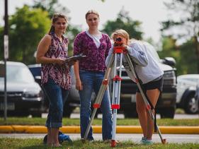 Three female students using surveying tools