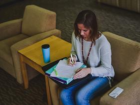 Female student writing in the Prairie Room