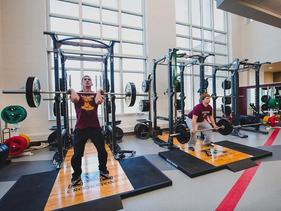 Two students in the weight room in the Wellness Center