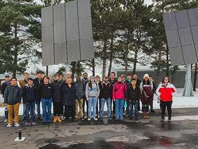 Students standing by large solar panels