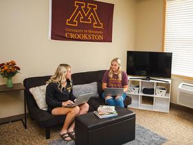 Two female students sitting in the living room of a Centennial Hall apartment